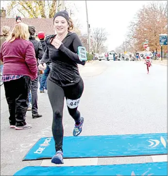  ?? Photo submitted ?? Danielle Kittrell crosses the finish line in the Frosty 5K in Bentonvill­e. She organized a Facebook group for beginner runners who meet once a week and talk about life and running.