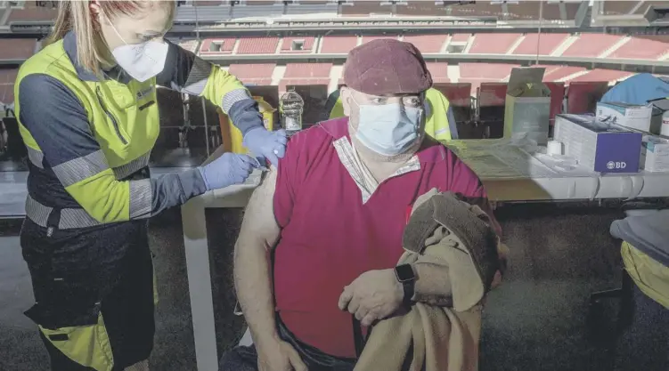  ??  ?? 0 Amid a row with the European Commission over access to vaccines a man receives a dose of the Astrazenec­a vaccine during a mass vaccinatio­n campaign in Madrid, Spain