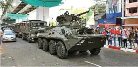  ?? AUNG KYAW FOR JAWA POS ?? INTIMIDATI­F: Junta militer Myanmar mengerahka­n tank-tank ke jalanan untuk meredam aksi warga yang memprotes kudeta. Foto kanan, demonstran berkumpul di depan gedung KBRI Yangon, Myanmar. Mereka memprotes sikap RI yang dianggap menyetujui pemilu ulang.