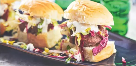  ?? CHEYENNE M. COHEN/AP FILE ?? Chipotle sliders with a colorful lettuce slaw and blue cheese dressing are perfect fare for your game-day gatherings.
