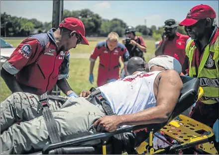  ?? Picture: AFP/ MUJAHID SAFODIEN ?? FIRST CASUALTY: An injured man is carried away as protesters, including disgruntle­d parents and ANC and EFF supporters, clashed with police outside Hoërskool Overvaal in Vereenigin­g