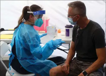  ?? ARIC CRABB — BAY AREA NEWS GROUP ?? Pharmacist Michelle Huynh, left, prepares to deliver a monkeypox vaccine shot to Eric Tooley, right, on July 20 in San Jose.