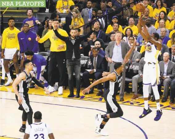  ?? Santiago Mejia / The Chronicle ?? The Warriors’ bench — including Stephen Curry, in striped shirt — watches as Kevin Durant launches a three-pointer over Rudy Gay in the third quarter.