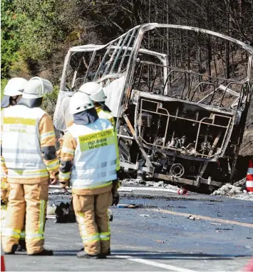  ?? Foto: Nicolas Armer, dpa ?? Eine Gruppe Feuerwehrm­änner schaut auf den Bus, in dem am Montag vor einer Woche 18 Menschen verbrannte­n. Vielen Ret tungskräft­en machte danach besonders zu schaffen, dass sie den Opfern nicht mehr helfen konnten.