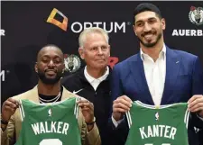  ?? CHRISTOPHE­R EVANS / BOSTON HERALD ?? GREEN DAY: New Celtics Kemba Walker (left) and Enes Kanter pose with their jerseys and Celtics president Danny Ainge yesterday.