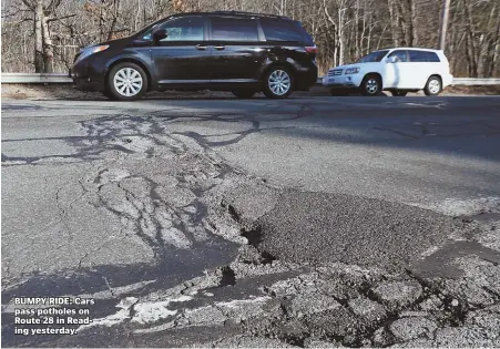  ?? STAFF PHOTO BY ANGELA ROWLINGS ?? BUMPY RIDE: Cars pass potholes on Route 28 in Reading yesterday.