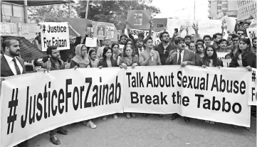  ??  ?? Pakistani human rights activists carry placards and banners during a protest against the rape and murder of a child in Karachi. — Reuters photo