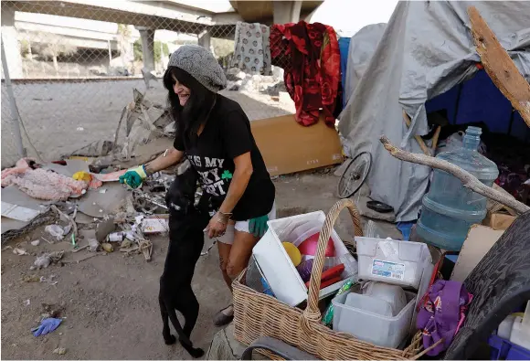  ??  ?? A RESIDENT of a homeless camp at 117th Street and Broadway in Los Angeles is seen last November.