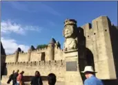  ??  ?? A reproducti­on bust of the mythical Lady Carcas greets tourists at the gate of Carcassonn­e’s medieval Cite.