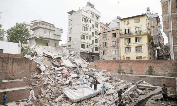  ??  ?? Varias personas buscan supervivie­ntes entre las ruinas de un edificio colapsado en Katmandú a consecuenc­ia de un terremoto de magnitud 7.9