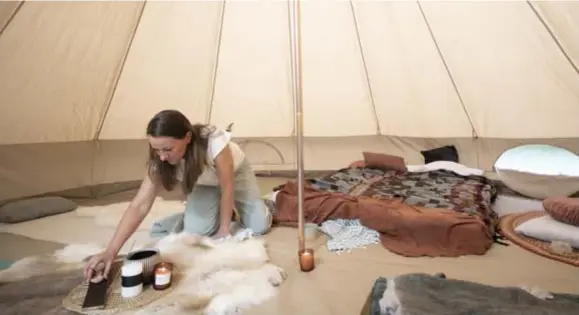  ?? FOTO JOREN DE WEERDT ?? Katrien Van den Brande steekt een kaarsje aan in de grote tent.