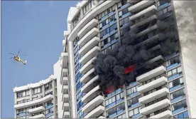  ?? MARCO GARCIA / ASSOCIATED PRESS ?? A fire burns Friday at the Marco Polo apartment complex in Honolulu after starting in a 26th-floor apartment. Three people were killed.