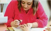  ?? MICHAEL D. PITMAN / STAFF ?? Abby O’Neal paints the nails of Vanessa Cannon, co-owner of True West Coffee. O’Neal opened Polished Hamilton, a nontoxic nail salon, inside Scripted Studio, 306 Main St., Hamilton, on Saturday.