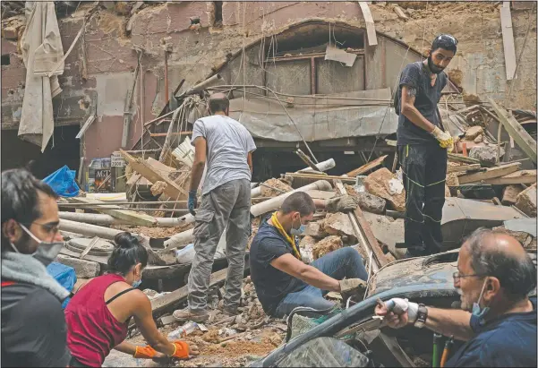  ?? (File Photo/AP/Felipe Dana) ?? People remove debris Aug. 7 from a house damaged by an explosion several days earlier in Beirut, Lebanon.