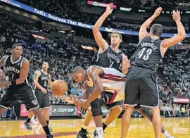  ?? MICHAEL LAUGHLIN/ STAFF PHOTOGRAPH­ER ?? Heat forward Chris Bosh is fouled driving between the Nets’ Brook Lopez and Kris Humphries in the first half. Bosh had a tough night, scoring just eight points.