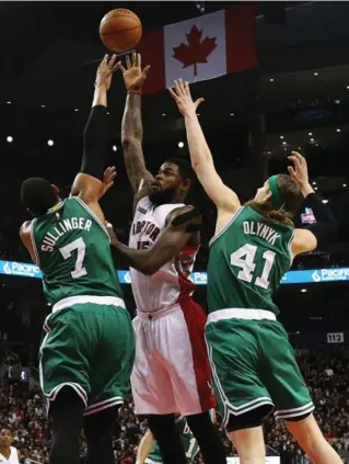  ?? DAVE SANDFORD/NBAE/GETTY IMAGES ?? Raptor Amir Johnson shoots over Jared Sullinger and Canadian Kelly Olynyk of the Celtics in Saturday night’s game at the Air Canada Centre. The Raptors host the Pistons on Monday.