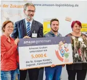  ??  ?? Bei der Spendenübe­rgabe der Aktion „Amazon gemeinsam“gab es nur glückliche Gesichter. Grabens Bürgermeis­ter Andreas Scharf (rechts) hat im Lager zwischen den 1,5 Millionen Einzelarti­keln seinen Favoriten gefunden.