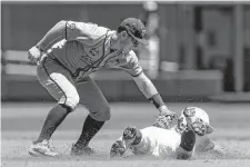  ?? John Peterson/associated Press ?? OU’S John Spikerman got tagged out by A&M’S Ryan Targac on this play, but little else has gone wrong for the Sooners at the CWS.