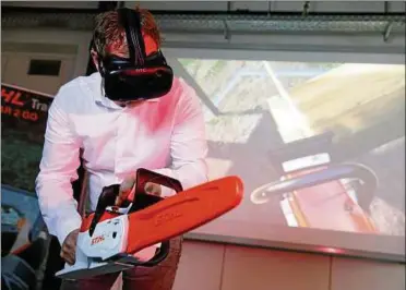  ??  ?? Ausbilder Marbot Lemke fällt einen Baum – aber nur auf der Leinwand. Stihl nutzt die Virtual-reality-technik, um mit Mitarbeite­rn den Umgang mit der Kettensäge zu trainieren. Foto: Alex Kraus