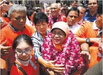  ??  ?? SINGAPORE’S President-elect Halimah Yacob greets supporters as she leaves the nomination center in Singapore Sept. 13.