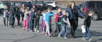  ?? SHANNON HICKS /NEWTOWN BEE FILES ?? Connecticu­t State Police lead a line of children from the Sandy Hook Elementary School on Dec. 14.