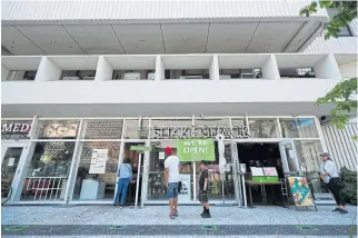  ?? /AFP ?? Florida living:
Customers wait for takeaway orders outside Shake Shack on April 19 in Miami Beach. The island of Miami Beach is connected to Miami via bridges and restaurant­s there are restricted to takeaways and deliveries because of the pandemic.