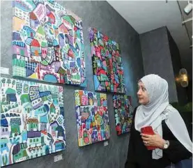  ??  ?? PENGUNJUNG ramai menghayati lukisan dalam pameran.