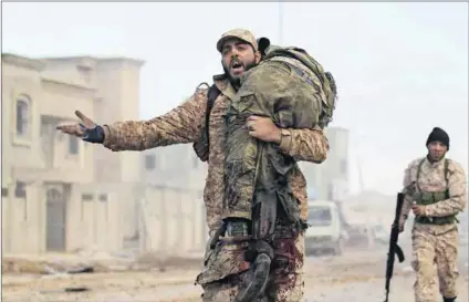  ?? Photo: Abdullah Doma/AFP ?? No end in sight: A member of the Libyan National Army carries an injured comrade during fighting against jihadists in Qanfudah, on the southern outskirts of Benghazi.