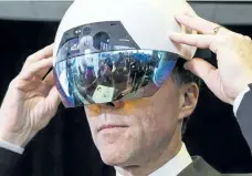  ?? CHRISTOPHE­R KATSAROV/THE CANADIAN PRESS ?? Finance Minister Bill Morneau wears an augmented reality helmet designed by Accenture Centre for Innovation during a tour of the Vector Institute at the MaRS Discovery District, in Toronto on Thursday.