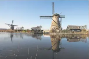  ?? Peter Dejong, The Associated Press ?? The 18th-century windmills that line Hooge Boezem van de Nederwaard canal were built to clear water from the low-lying landscape in Kinderdijk, Netherland­s.