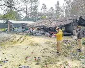  ?? PTI ?? Policemen inspect the site where seven people, including three children, were killed after inhaling poisonous gas in a carpet factory at Jalalpur village in Bisvan area of Sitapur on Thursday.