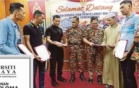  ?? FOTO: IMRAN MAKHZAN ?? AZLIMIN (tiga dari kanan) bersama Timbalan Pengarah JBPM Terengganu, Sharikan Bustamam (empat dari kiri) melihat surat perhargaan kepada lima Wira Pulau Warisan yang membantu menyelamat­kan lima wanita hampir lemas selepas pacuan empat roda terjunam ke sungai di Pulau Warisan.