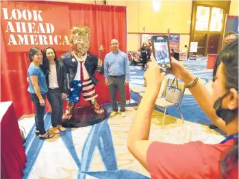  ?? JOHN RAOUX/AP ?? CPAC attendees pose for a photo next to a statue of former President Trump on Saturday in Orlando, Fla. There’s a possibilit­y Trump will run for president in 2024. But as the Trump Party takes over the GOP, antiTrump Republican­s are abandoning the party in droves.