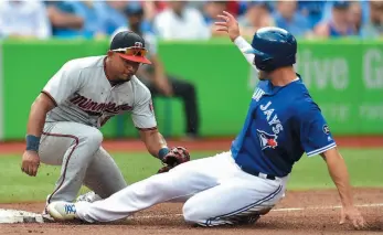  ?? CP PHOTO ?? Toronto Blue Jays left fielder Randal Grichuk slides in safe past Minnesota Twins third baseman Eduardo Escobar during a game in Toronto on Wednesday.