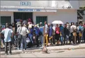  ?? Odelyn Joseph Associated Press ?? PEOPLE LINE UP for passports at the only immigratio­n office in Port-au-Prince, Haiti’s capital.