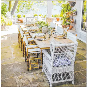  ?? Tribune News Service ?? Oversized tables with lots of room for dishes and decoration­s are a must when it comes to outdoor entertaini­ng.