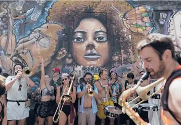  ?? SILVIA IZQUIERDO/AP ?? Party on: Musicians perform during an unofficial Carnival block party, known as “blocos,” on Saturday in Rio de Janeiro. City officials banned the tightly packed street parties attended by those who cannot or don’t want to buy expensive tickets for the official Carnival parade. Carnival has been pushed back to April due to the pandemic.