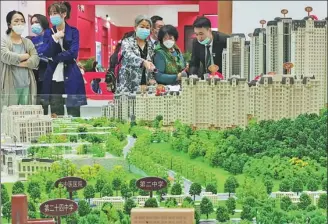  ?? LIU DEBIN / FOR CHINA DAILY ?? Potential homebuyers look at a property model during an industry expo in Dalian, Liaoning province, on Monday.