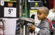  ?? ELAINE THOMPSON — THE ASSOCIATED PRESS ?? A boy looks over a Black Friday sale item at a J.C. Penney store Friday in Seattle.