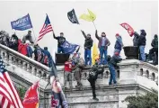  ?? AP FILE ?? Rioters wave flags at the U.S. Capitol, on Jan. 6, 2021. Geoffrey Sills, 31, was convicted of assault, obstructio­n of Congress and robbery for his role in the attack.