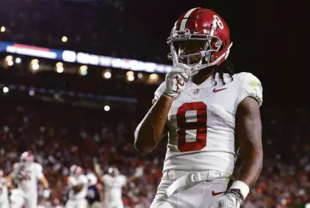  ?? Kevin C. Cox / Getty Images ?? Alabama wide receiver John Metchie III silences the crowd after scoring in the fourth overtime to defeat host Auburn 24-22.