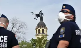  ??  ?? Police officers in Szolnok, Hungary, use a drone to find residents failing to comply with the stay-at-home order. Photograph: Janos Meszaros/EPA