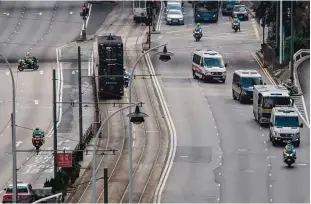  ??  ?? HONG KONG: A prison van (far right-third from front) transporti­ng British banker Rurik Jutting, 31, accused of the murders of two Indonesian women, drives on a blocked road with a police convoy as it approaches the High Court in Hong Kong. —AFP