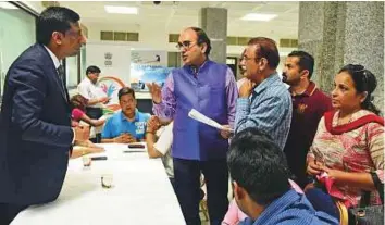  ?? Arshad Ali/Gulf News ?? ■ Vipul (centre) speaks to a consul during the Open House yesterday. Expats can raise issues like labour disputes, marital issues, document delays at the forum.