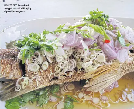  ??  ?? FISH TO FRY: Deep-fried snapper served with spicy dip and lemongrass.