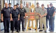  ?? Jeremy stewart ?? Cedartown firefighte­rs join Fire Chief Felix White and his son, Cedartown Police Cpl. Bryce Momon, in presenting White with a special plaque during his retirement reception Thursday, March 30.