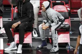  ?? AP photo ?? Grizzlies guard Ja Morant wears a boot on his left foot after suffering an ankle injury during Memphis’ 116-111 overtime victory over the Brooklyn Nets on Monday.
