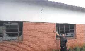 ??  ?? Venancio Borja, secretario de la escuela Juan de la Cruz Vázquez, muestra las fisuras que del techo bajan por las paredes.