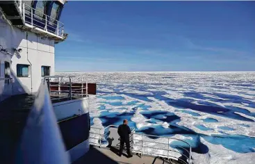  ?? David Goldman / Associated Press ?? Canadian Coast Guard Capt. Victor Gronmyr looks out over the ice covering the Victoria Strait as the Finnish icebreaker MSV Nordica traverses the Northwest Passage through the Canadian Arctic Archipelag­o. Sea ice that foiled famous explorers has slowly...