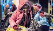  ?? / R. Steven Eckhoff ?? Avenia Spivey, 8, and Cheseray Rodgers, 6, of Rome, wait for the downtown Christmas parade.